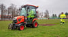 Bauhofmitarbeiter glätten Rasen auf dem Fußballfeld am Volkshaus