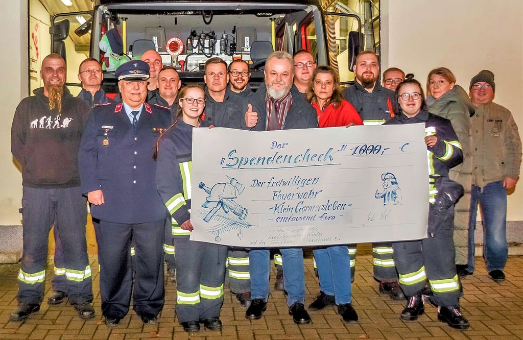 Die Mitglieder der Freiwilligen Feuerwehr Klein Germersleben mit ihrem Stendescheck über 1000 Euro .