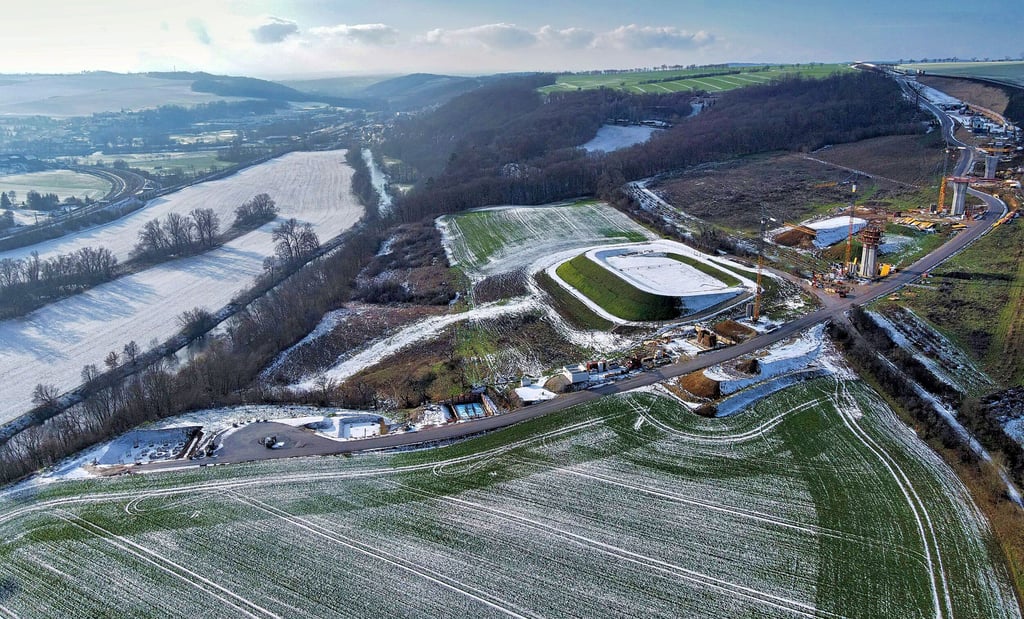 Drohnenblick von Stendorf auf Baustraße, Regenrückhaltebecken und erste Pfeiler der zu bauenden Saalebrücke der Ortsumfahrung Bad Kösen der B87n. Rechts hinauf führt die Trasse Richtung Taugwitz; im Tal im Hintergrund ist Großheringen zu sehen.