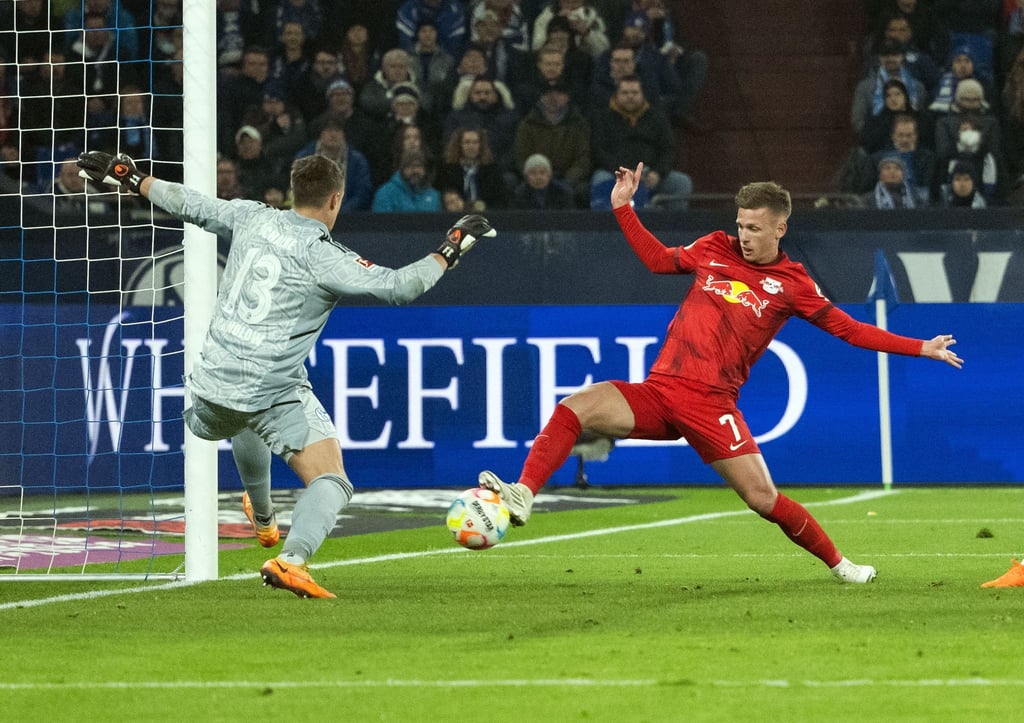 Schalkes Torhüter Alexander Schwolow und Dani Olmo von Leipzig versuchen an den Ball zu kommen.