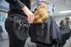 Eine Friseurmeisterin schneidet einer Kundin die Haare.