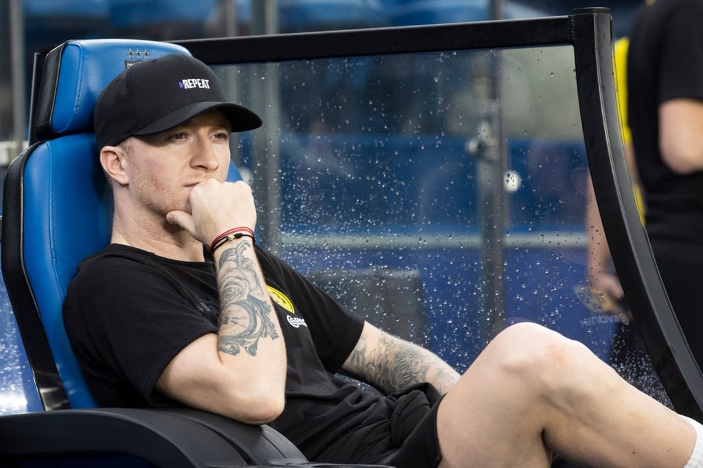 Borussia Dortmunds Marco Reus sitzt auf der Bank.