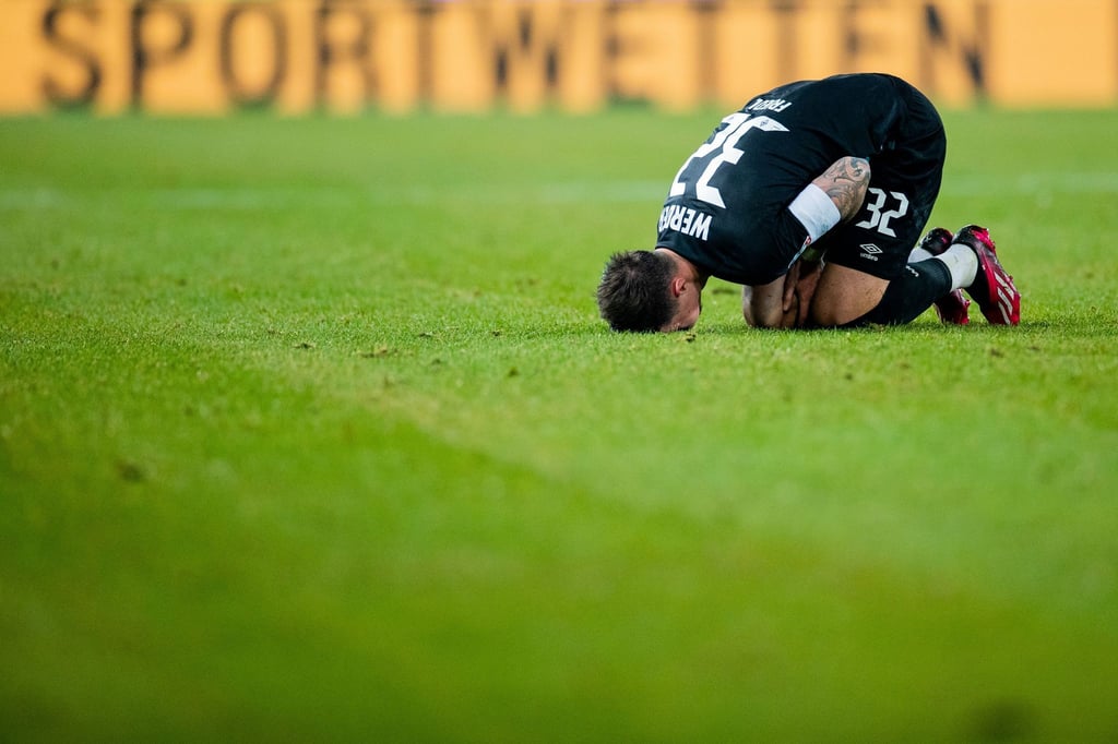 Bremens Kapitän Marco Friedl liegt auf dem Rasen.