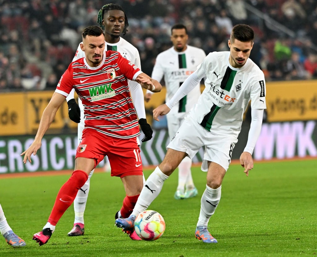 Der Augsburger Mergim Berisha (l) und Julian Weigl (r) von Mönchengladbach.