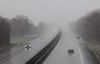 Schnee und Regen behindern den Verkehr auf einer Autobahn.
