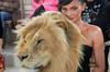 Kylie Jenner hinter einem täuschend echt aussehenden Löwenkopf.