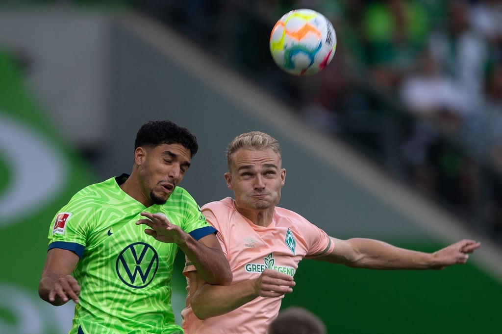 Wolfsburgs Omar Marmoush (l) spielt gegen Bremens Amos Pieper.