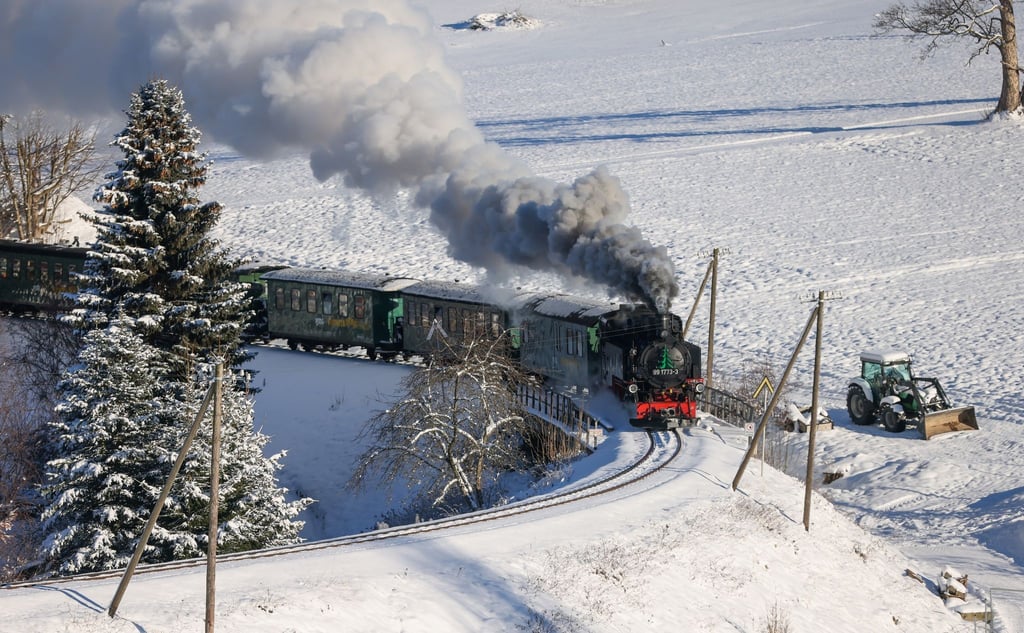Mit reichlich Rauch bahnt sich die Fichtelbergbahn ihren Weg durch das verschneite Erzgebirge.