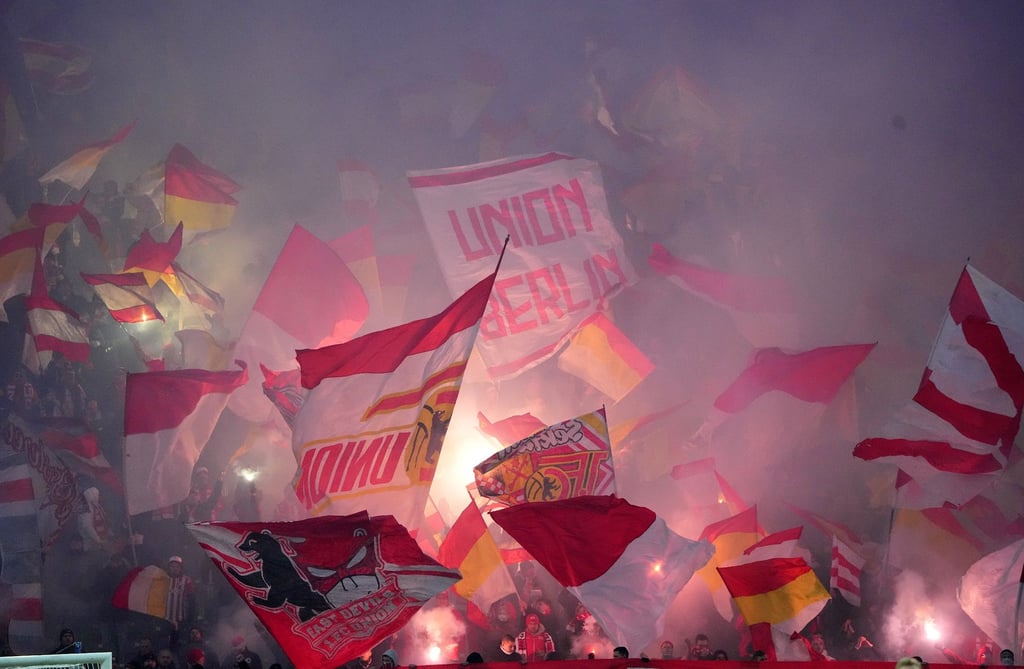 Die Fans von Union haben Pyrotechnik gezündet und schwenken Fahnen.