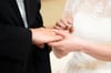 Ein Brautpaar steckt sich während der Trauung in der Kirche die Ringe an. Der Hochzeitsstau nach der Coronakrise scheint gebrochen.