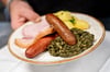 Grünkohl mit den traditionellen Beilagen Salzkartoffeln, Kochwurst, Pinkelwurst und Kasseler wird im Restaurant „Bümmersteder Krug“ serviert.