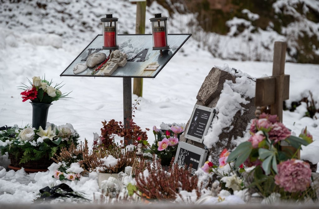 Ein Gedenkstein, eine Gedenktafel, Engelfiguren und Blumen erinnern auf einem Parkplatz bei Kusel an die beiden Polizisten, die vor einem Jahr im Dienst getötet wurden.