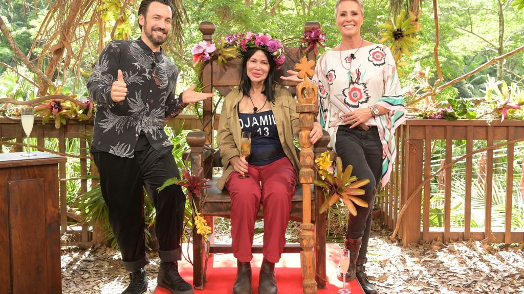Djamila Rowe sitzt nach dem Sieg beim RTL-Dschungelcamp 2023 mit ihrer Krone auf ihrem Thron. Neben ihr stehen Moderatorin Sonja Zietlow (r) und Moderator Jan Köppen.