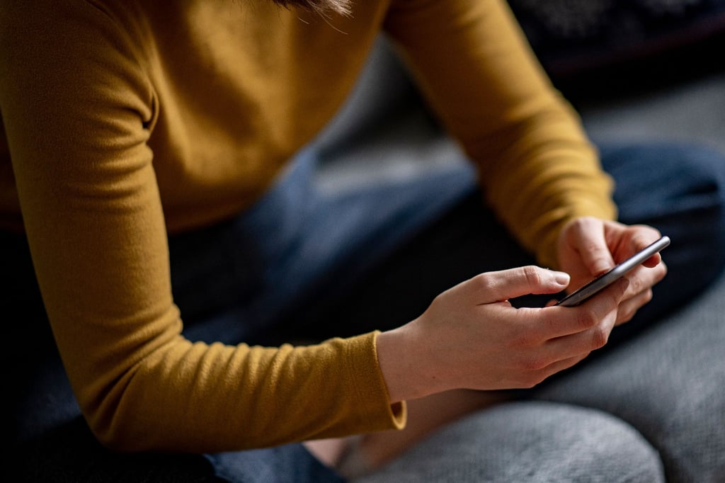 Eine Frau hält ein Smartphone in den Händen.