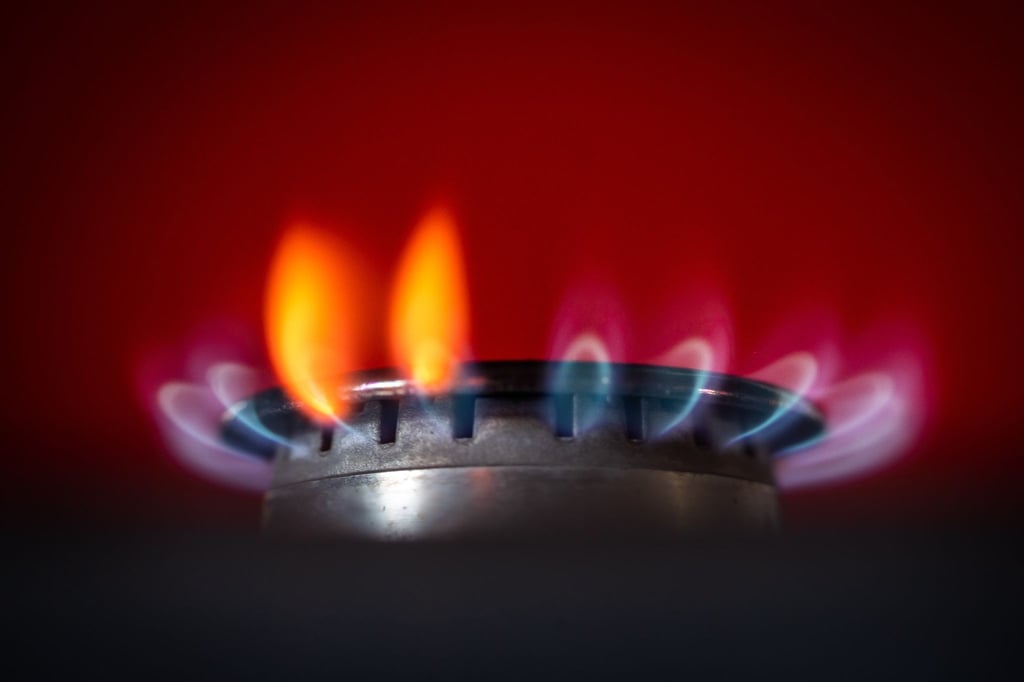 Die Flamme eines Gasherdes brennt in einer Küche.