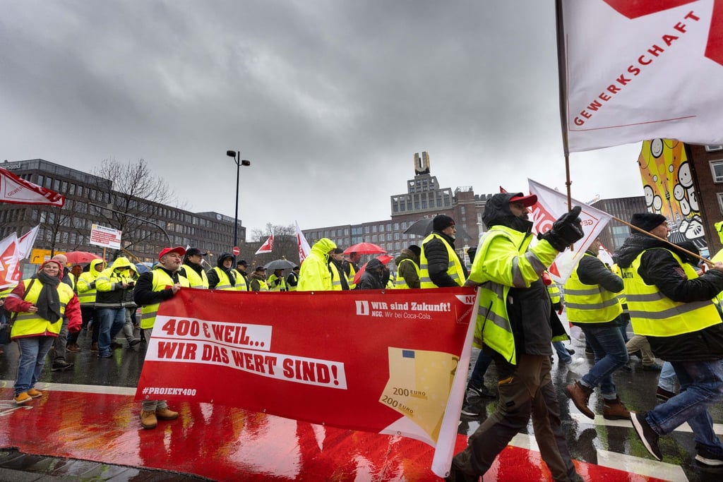 Coca-Cola-Beschäftigte verleihen mit einem Demonstrationszug ihren Forderungen Nachdruck.