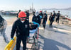 Gerettete Besatzungsmitglieder werden von Rettungskräften auf Bahren getragen, als sie in einem Hafen in Mokpo in Südkorae ankommen.