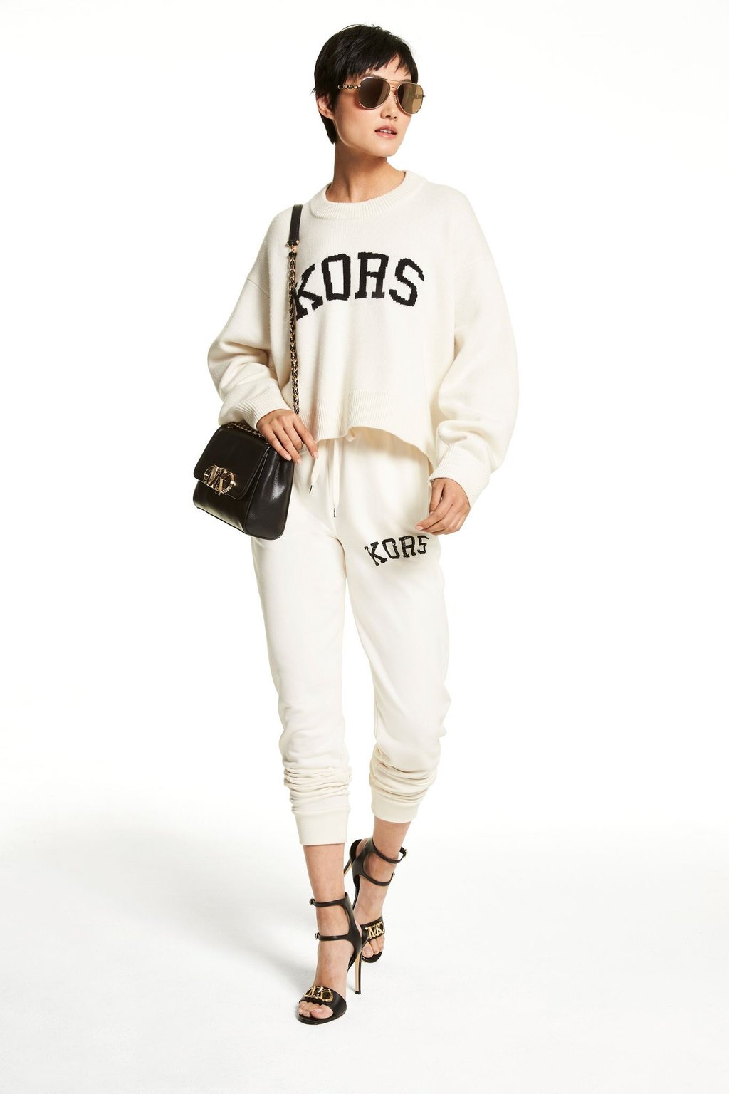 Mit schicken Schuhen wird die Jogginghosen-Mode sogar ausgetauglich. Hier ein Beispiel von MICHAEL Michael Kors (Sweater ca. 275 Euro, Jogger ca. 175 Euro, Sonnenbrille ca. 160 Euro, Tasche ca. 498 Euro, High Heels ca. 155 Euro).