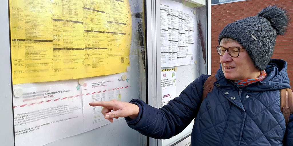 Kristina Bohnert deutet auf den unvollständigen Hinweis am Fahrplanaushang der Deutschen Bahn in Salzwedel.