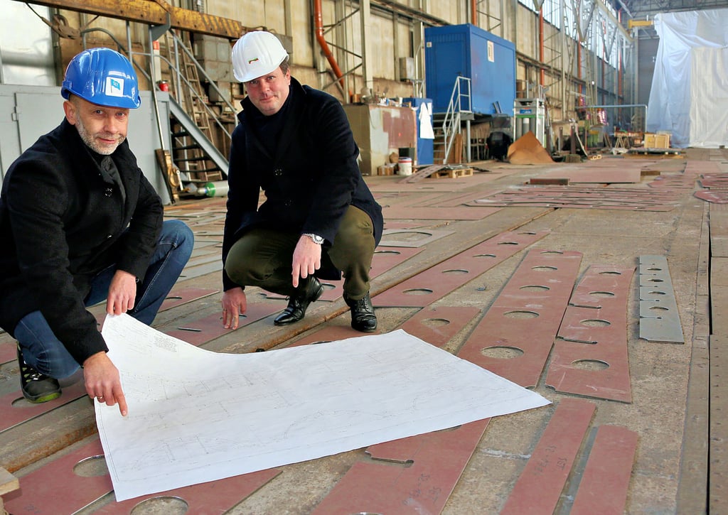 SET-Chef Olaf Deter (links) und HADAG-Vorstand Tobias Haack mit Bauplan und Schiffsteilen in der Tangermünder Werfthalle