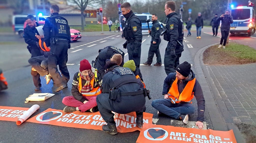 Junge Klimaaktivisten der Letzten Generation hatten am Montagmorgen mitten im Berufsverkehr die Fahrbahn der B1 in Magdeburg auf dem Werder stadteinwärts blockiert und sich teils dort festgeklebt.