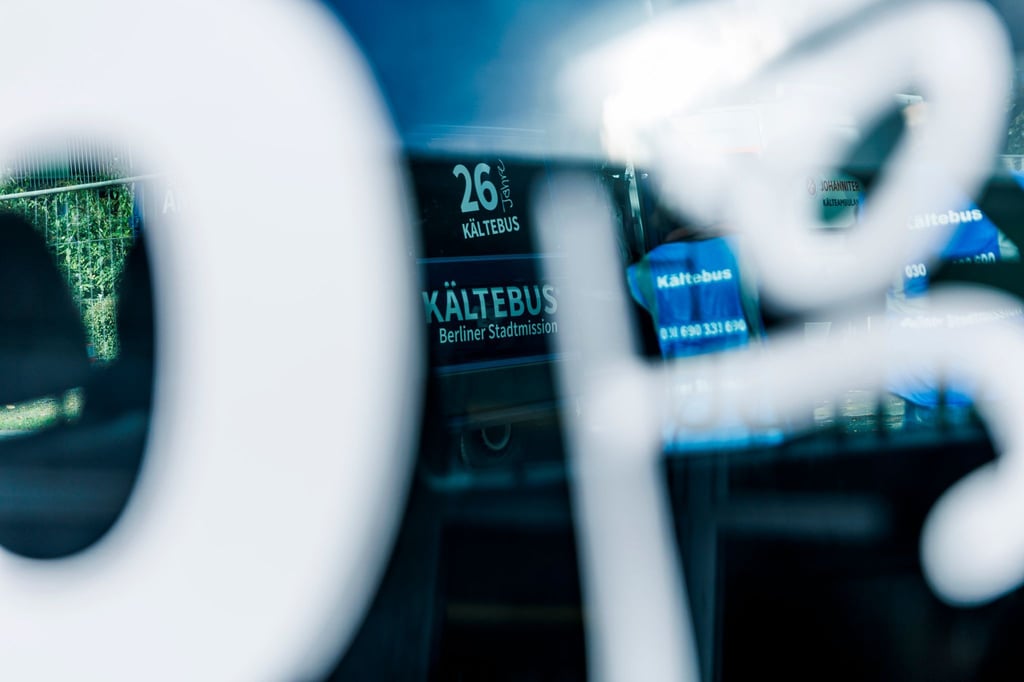Mitarbeiter stehen vor Fahrzeugen der Kältehilfe.
