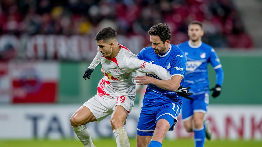 Leipzigs Andre Silva (l.) hält sich Hoffenheims Thomas Delaney vom Leib.