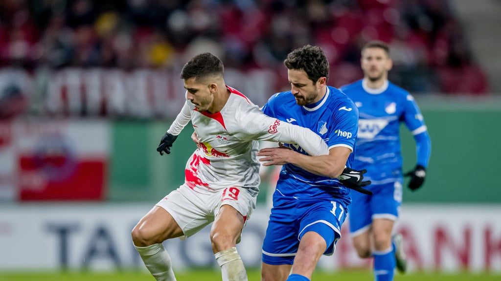 Leipzigs Andre Silva (l.) hält sich Hoffenheims Thomas Delaney vom Leib.