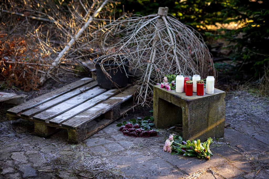 Blumen und Kerzen liegen an einer Tannenbaumschonung in Wunstorf-Blumenau in der Region Hannover.