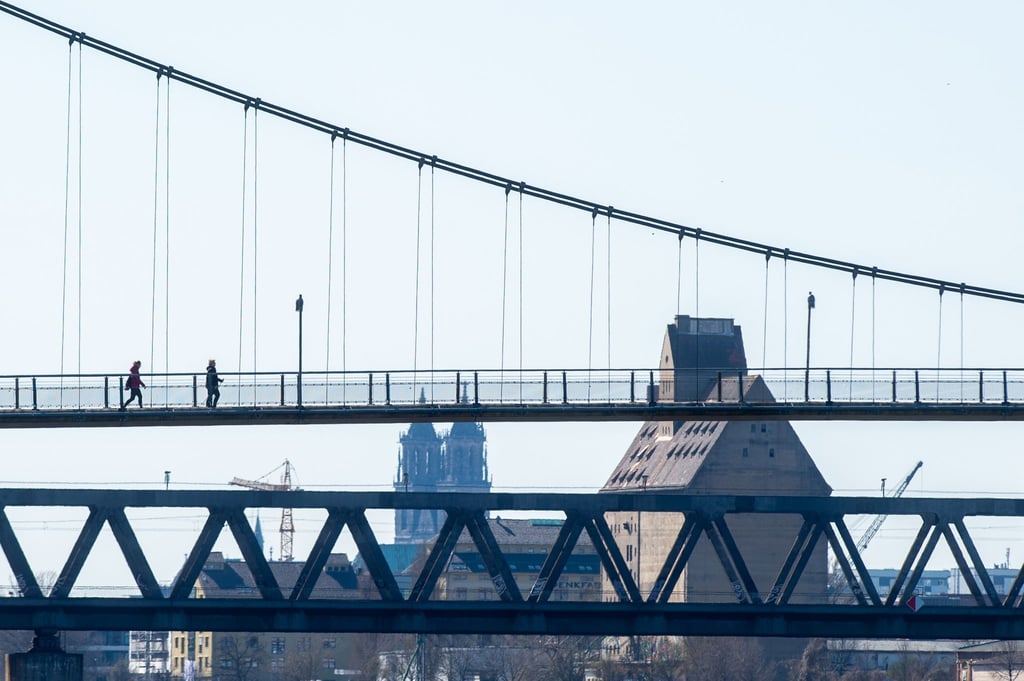 Zwei Fußgänger gehen über eine Elbbrücke.
