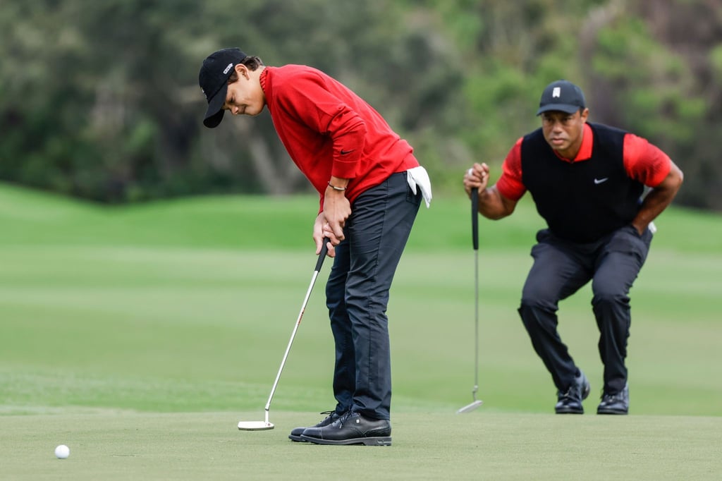 Tiger Woods schaut seinem Sohn Charlie Woods beim Putten zu.