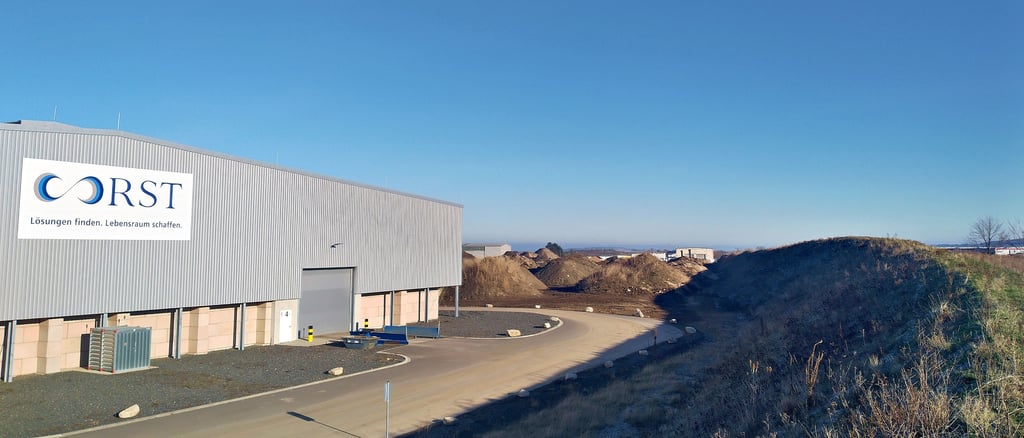 Blick auf eine der Aufbereitungshallen für gefährliche mineralische Abfälle und den bereits bestehenden Lärm- und Staubschutzwall im Süden und Westen der Anlage bei Timmenrode.