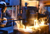 Im Schmelzbetrieb einer Gießerei füllt ein Gießereimechaniker das bei etwa 1.600 Grad Celsius geschmolzene Metall in Formen für Pumpenspiralgehäuse.