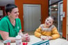 Juliane Paulick sitzt neben ihrer Tochter Soé an einem Tisch im Kinderhospiz „Pusteblume“.