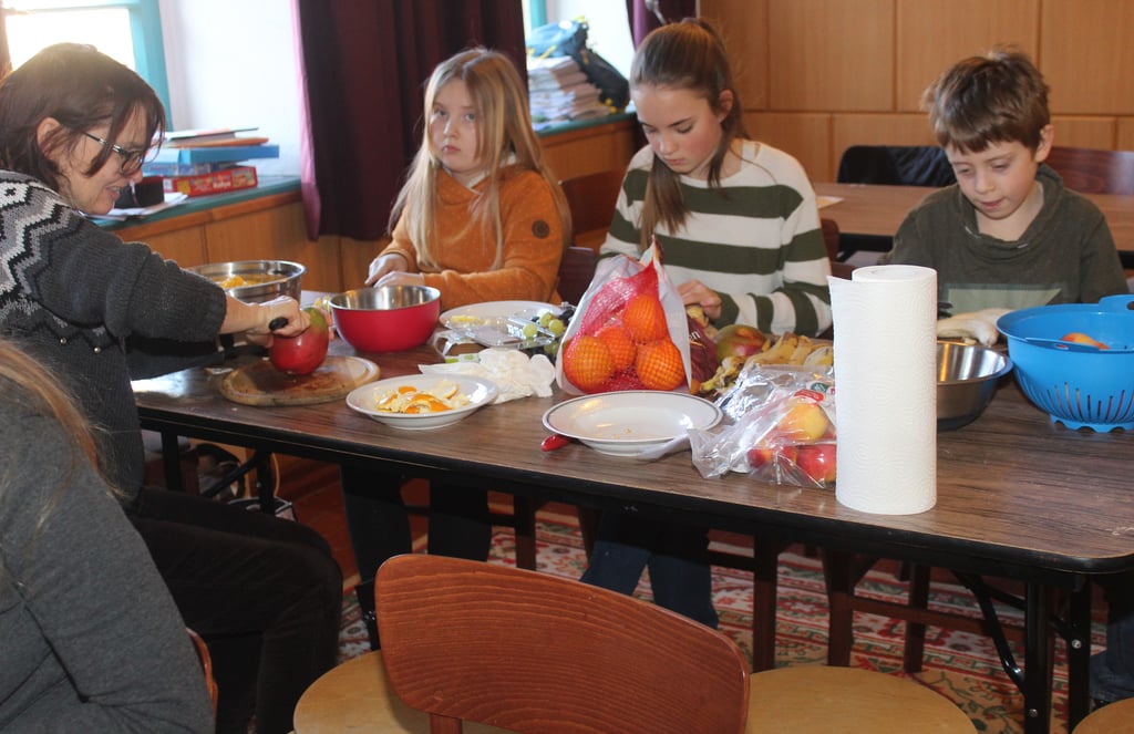 Äpfel, Bananen und Orangen – für einen leckeren Obstsalat schnippelten die Kinder mit Anett Hocke (l.) alles schön klein.
