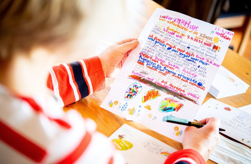 Eine Frau ließt einen Brief, den Kinder einer Schulklasse an den Osterhasen geschrieben haben.