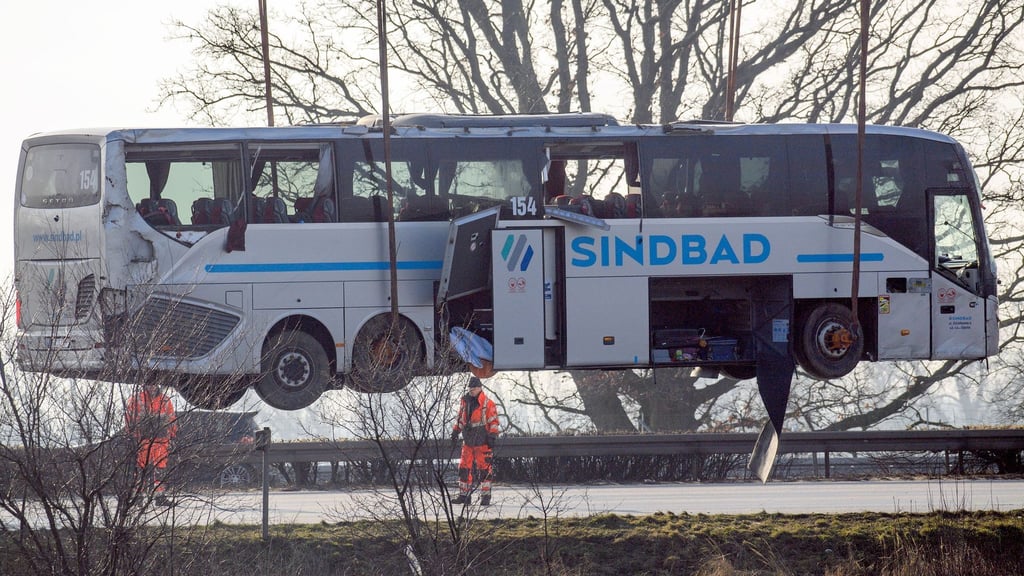 Ein Kran hebt den verunglückten Reisebus zurück auf die Fahrbahn.