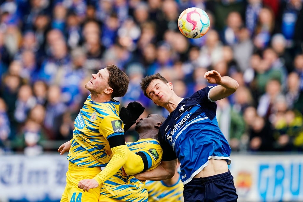 Braunschweigs Linus Gechter (l-r), Braunschweigs Tarsis Bonga und Darmstadts Christoph Zimmermann kämpfen um den Ball.