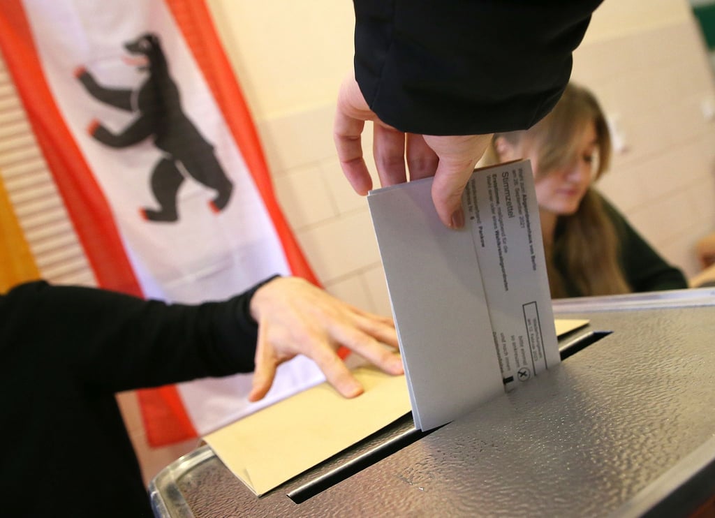 Eine Frau gibt ihre Stimme für die Wahl zum Berliner Abgeordnetenhaus ab und wirft ihren Wahlzettel in die Wahlurne.