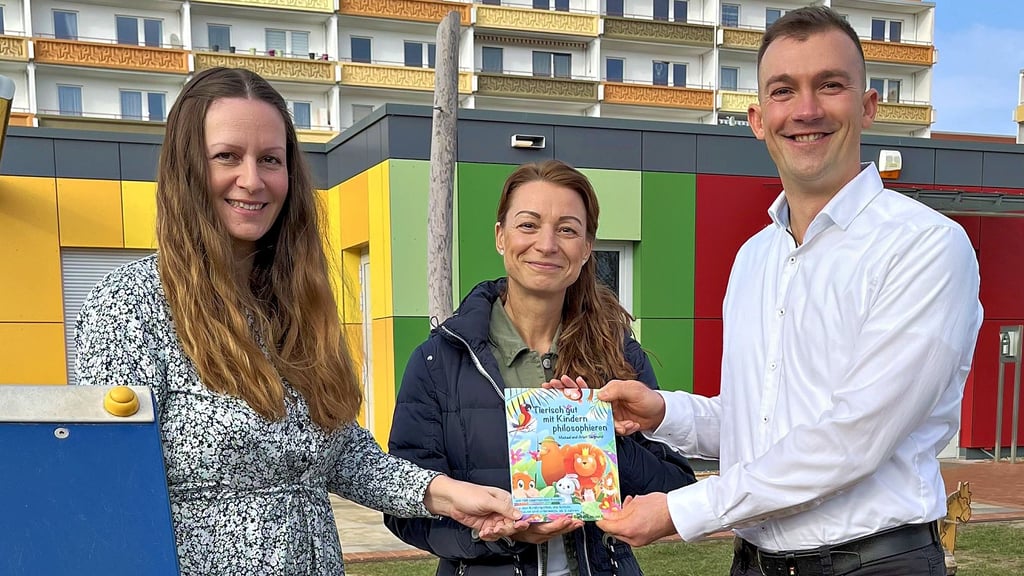 Arlett und Michael Siegmund überreichen das erste Exemplar ihres kleinen neuen Buches an die Leiterin der Tangermünder DRK-Kindertagesstätte „Sausewind“, Christiane Köhn.