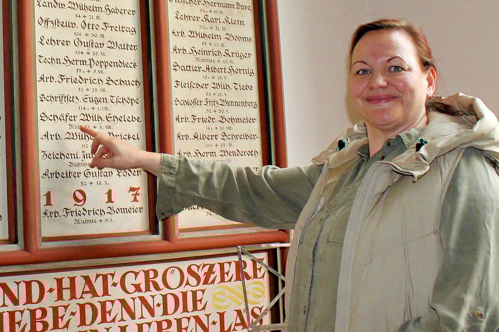 Anja Meyer an der restaurierungswürdigen Gedenktafel für Kriegsgefallene in der Stephanii-Kirche in Heudeber. Die Neugestaltung der Tafel ist das nächste Vorhaben der Kirchengemeinde.
