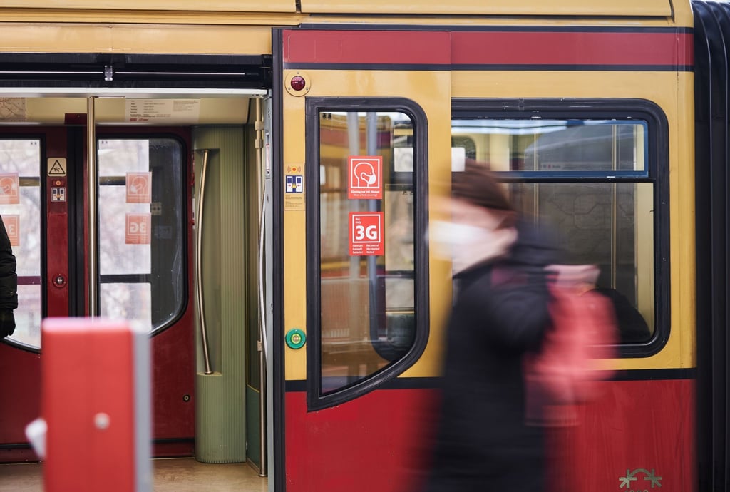 Eine Frau geht an einer S-Bahn vorbei.