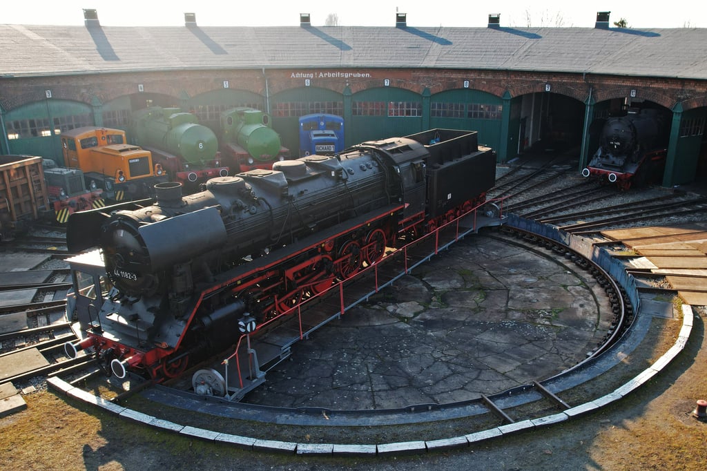 Eine historische Dampflokomotive steht auf der Drehscheibe vor dem Ringlokschuppen der Eisenbahnfreunde im Lokschuppen in Staßfurt.