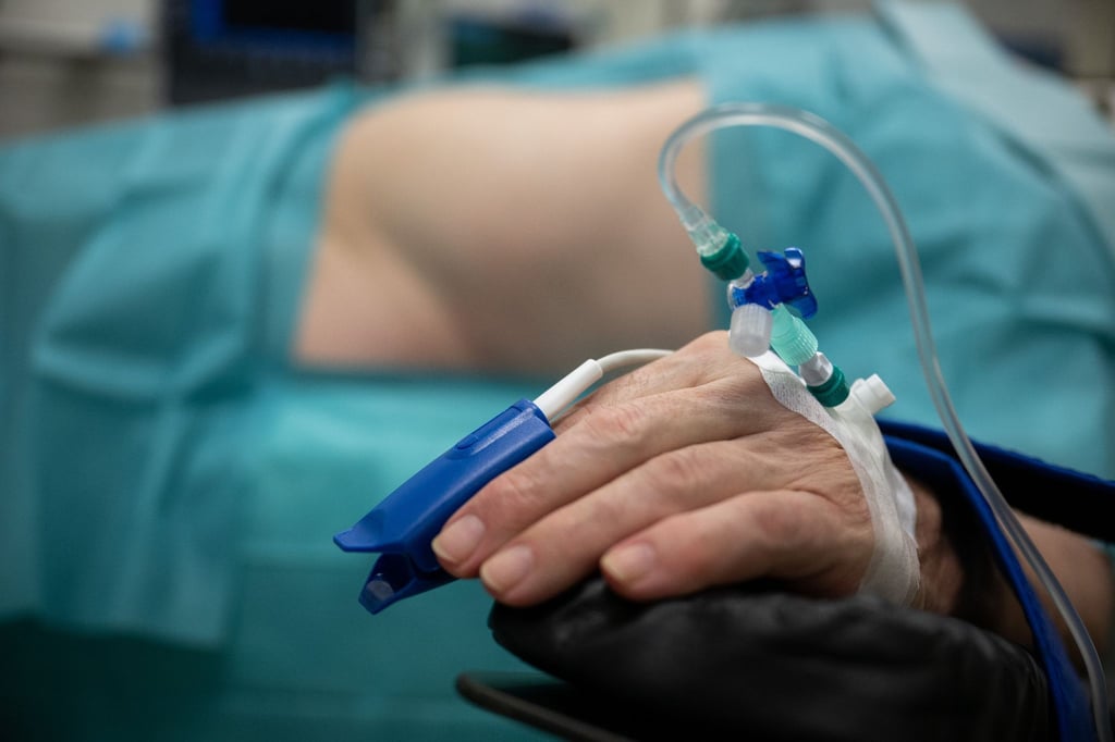 Ein bereits narkotisierter Patient liegt in einem Raum zur Vorbereitung einer Operation in einem Krankenhaus.