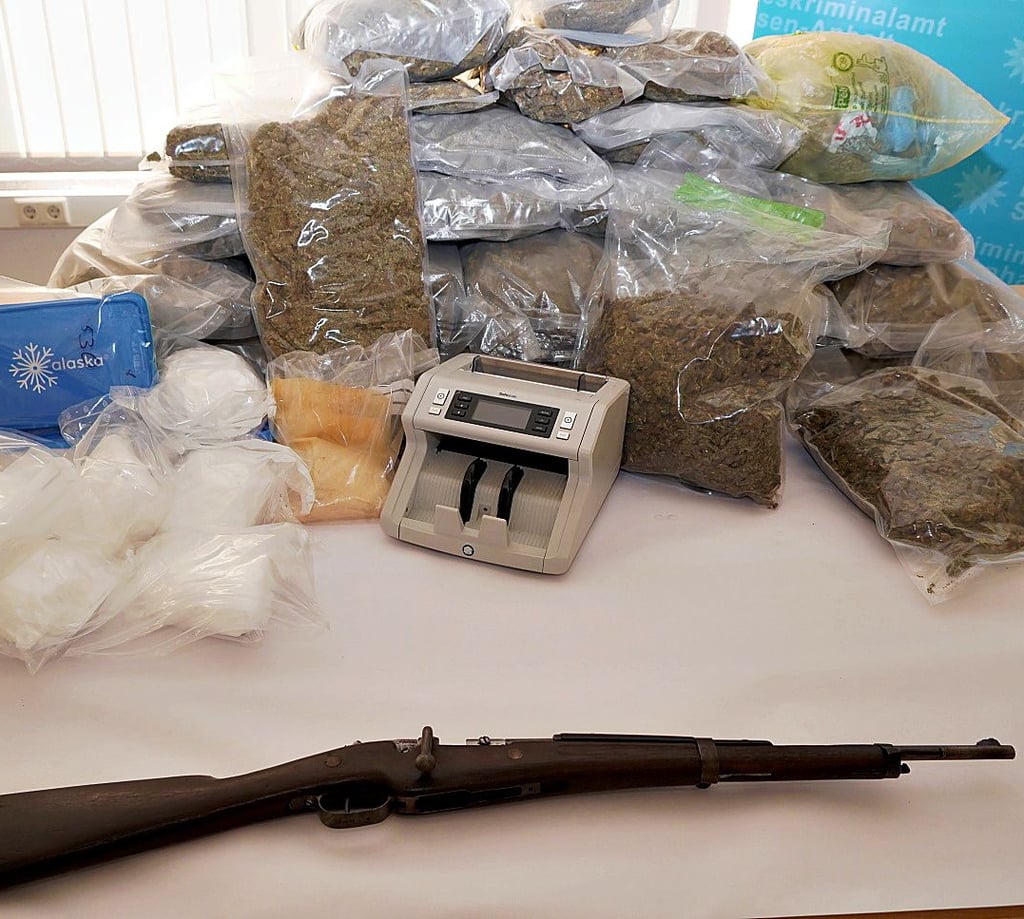 Die sichergestellten Drogen, eine Geldzählmaschine und ein Gewehr liegen auf einem Tisch im Landeskriminalamt.