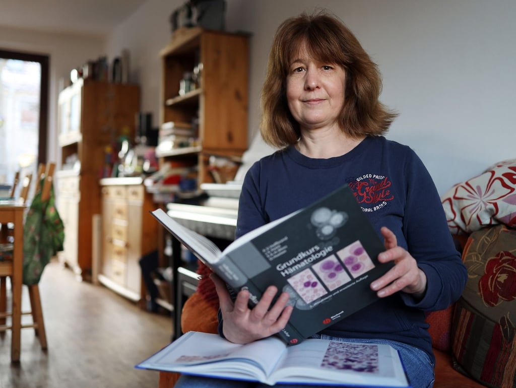 Ins Grundlagen-Buch schaut Dr. Tabea Appel nur fürs Foto: Die Ärztin ist in Halle heimisch geworden.