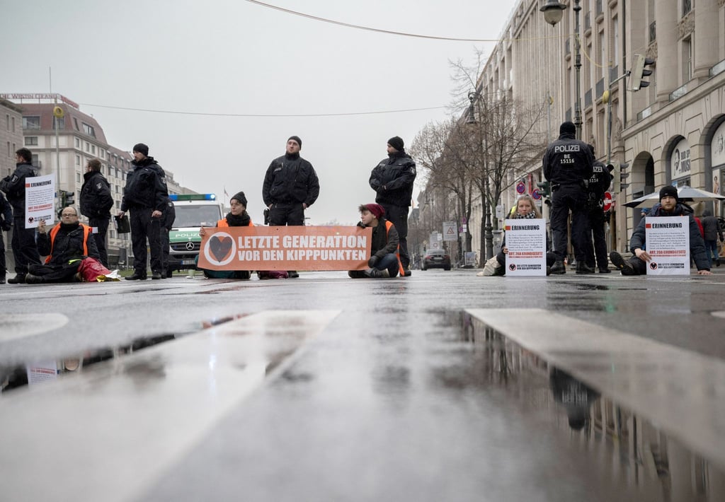 Mitglieder der Umweltschutz-Gruppe „Letzte Generation“ blockieren eine Kreuzung auf der Straße „Unter den Linden“.