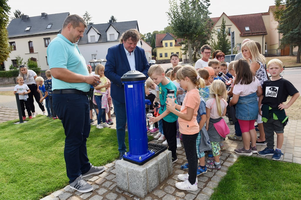 Midewa-Geschäftsführer Uwe Störzner (2.v.r.) übergibt einen Trinkbrunnen.