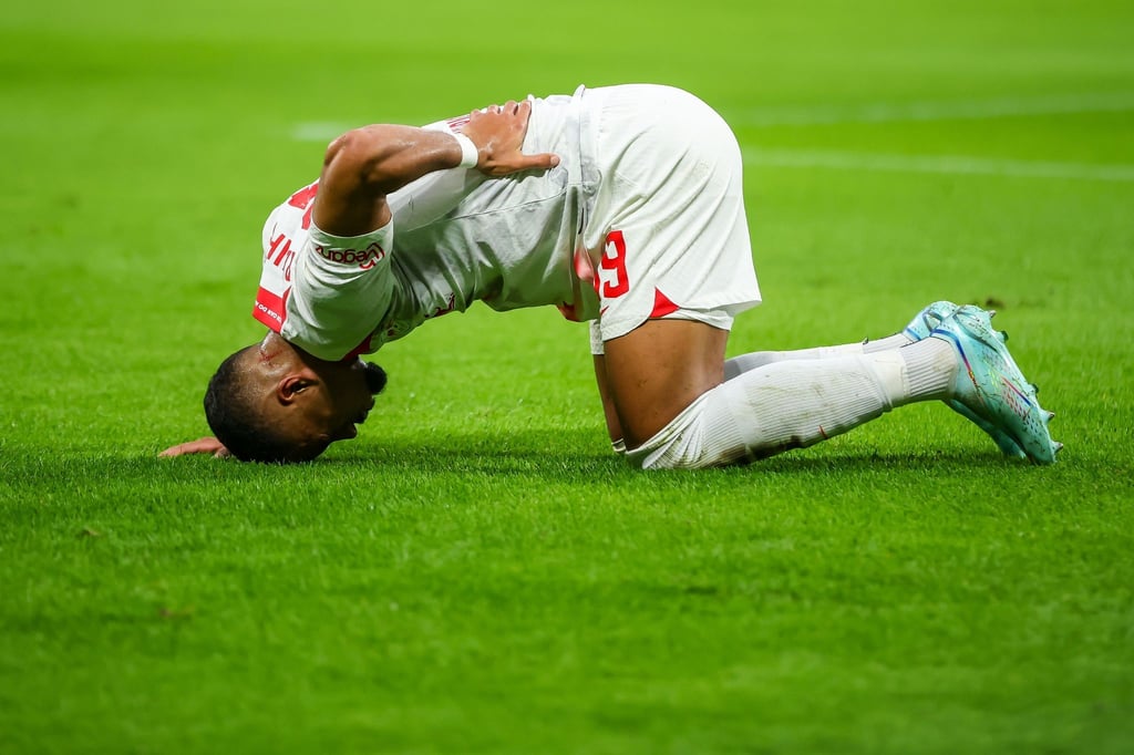 Leipzigs Spieler Benjamin Henrichs liegt nach einem Zusammenstoß am Boden.