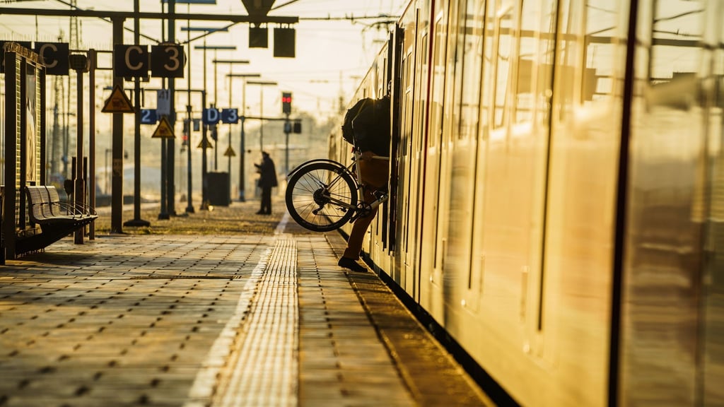 Ein Fahrgast steigt mit seinem Rad in eine S-Bahn.